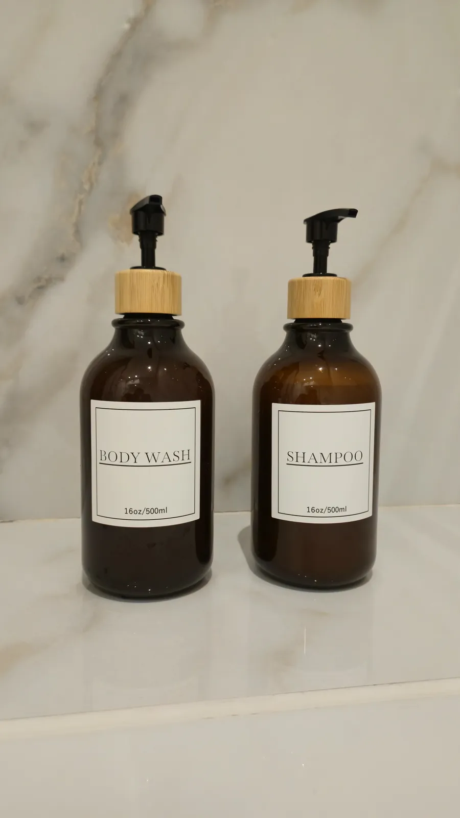Shampoo and body wash amber bottles on marble
