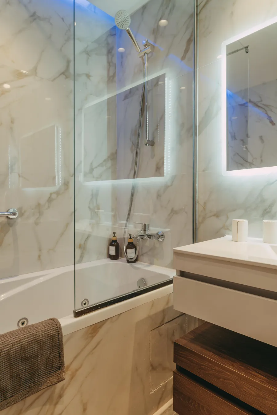 Glass walk-in shower with marble walls