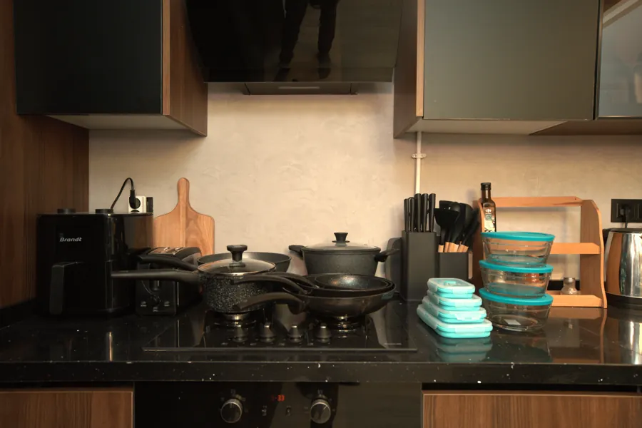 Kitchen counter with air fryer, pots and pans on the stove, knife block and containers
