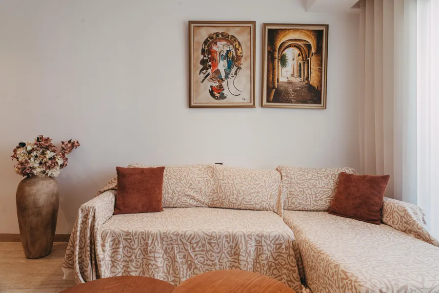Living room wall with Tunisian paintings above the sofa