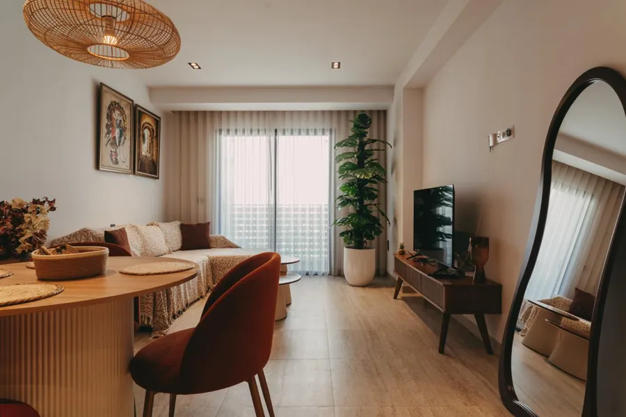 Bright living room with boho décor, dining table and TV