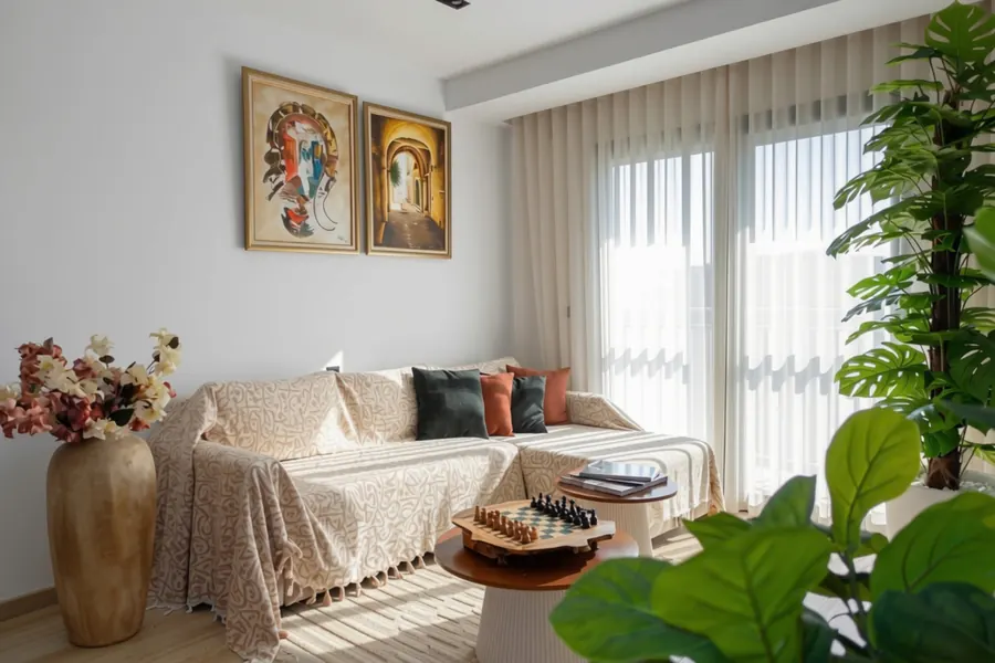 Living room sofa under Tunisian paintings, with a chess board on the coffee table