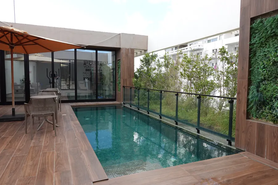 Pool terrace with parasol, chairs and wooden deck